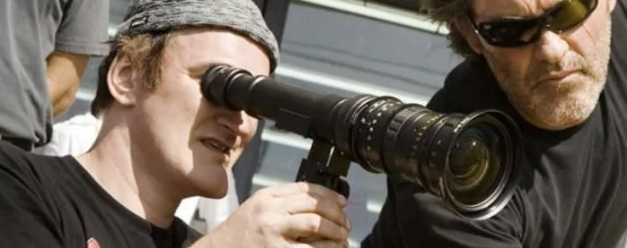 Zwei Männer richten eine Filmkamera mit langem Objektiv aus