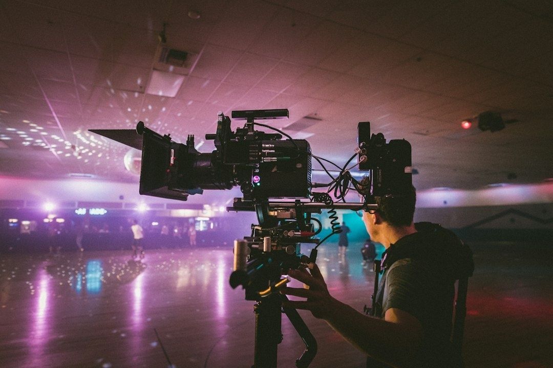 Kameramann filmt mit einer großen Filmkamera in farbig beleuchteter Halle